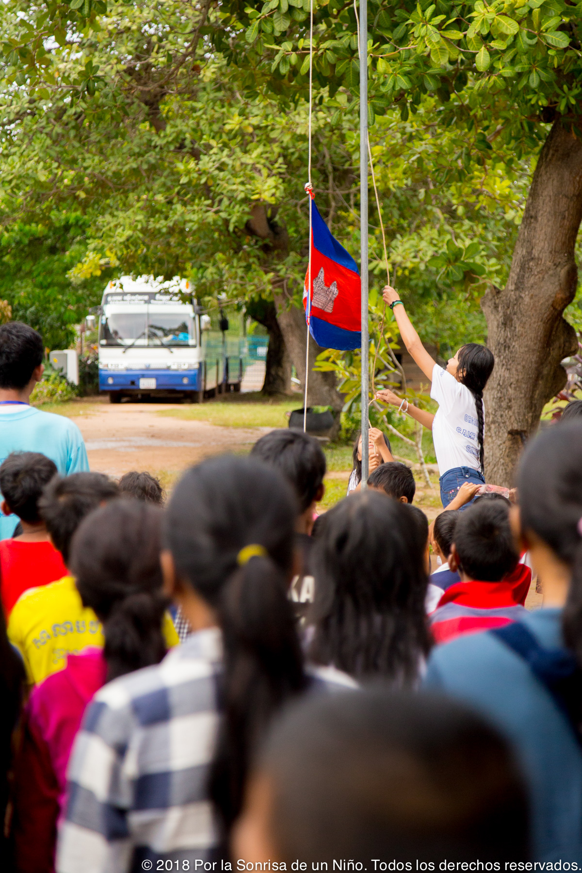 Una niña iza la bandera