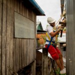 Andrea finit de clouer les plaques de tôle sur les murs.