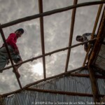 Le propriétaire aidant l'équipe de construction à finir la reconstruction de sa maison.