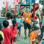 A Khmer monitor dancing in the middle of the kid's chuchuas, down the toboggan.